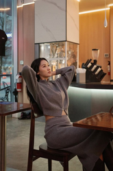 a lady in a grey wool cardigan and a grey wool skirt